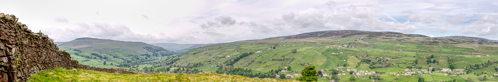 A panoramic of a dry stacked stone wall with a cloudy sky Yorkshire Dales United Kingdom