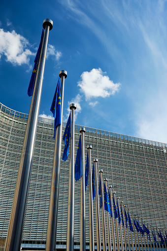 Helplessly drooping EU European Union flags with the European Comission building in Background. Brussles, Belgium