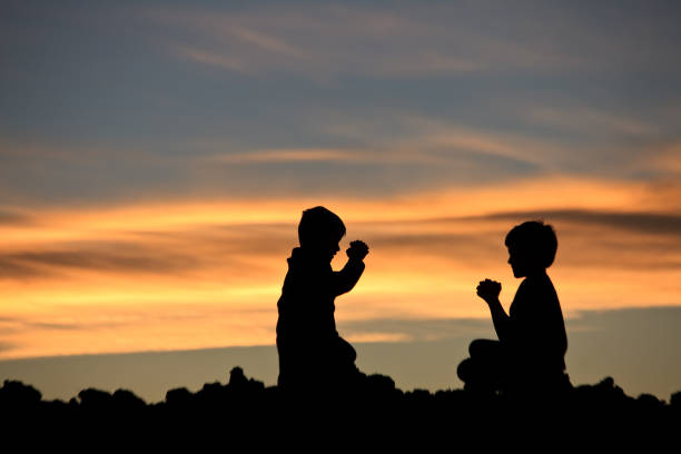 istock Two Boys Praying at Sunset 1227413207