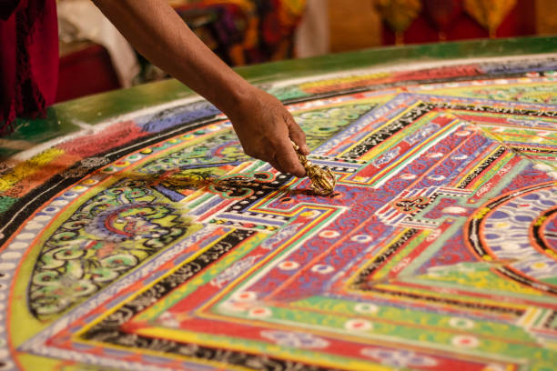 las manos de un monje que trabaja en un mandala tibetano - kaza fotografías e imágenes de stock