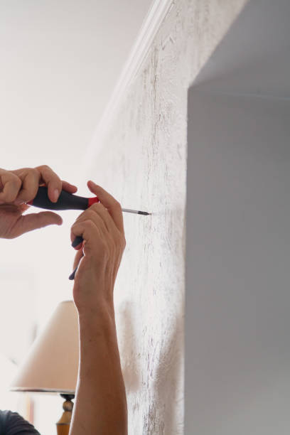 istock Hands screw screw into  wall of room 1227413469