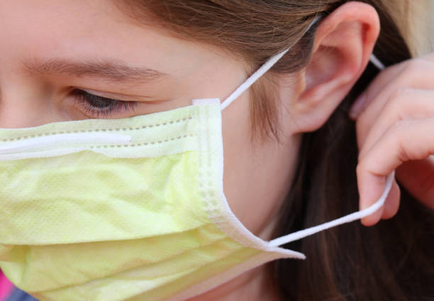 istock child properly wearing surgical mask with elastic behind the ear 1227413933
