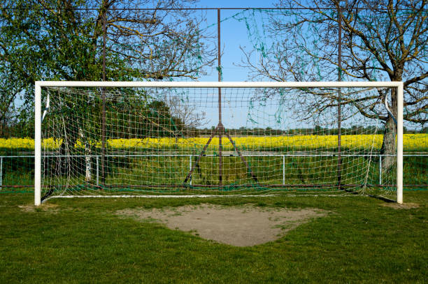 Behind the ropes of the outdoor soccer field goal net, the football goal background