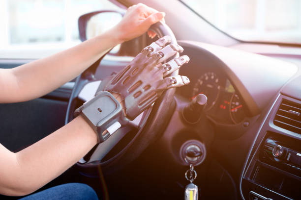 A person with a prosthetic hand printed on a 3d printer at the wheel of a car. Concept of practical application of 3D printing. A person with a prosthetic hand printed on a 3d printer at the wheel of a car. Concept of practical application of 3D printing. 3d printing hand stock pictures, royalty-free photos & images