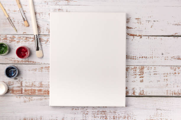 istock Colorful creative table with blank canvas for sketches and paints, paintbrushes set on white wooden table, top view, copy space, flat lay style, drawing class education 1227420678