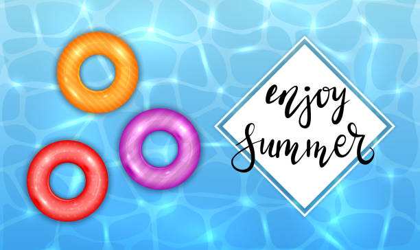istock Enjoy Summer and Colored Swim Rings on Water Background 1227423967