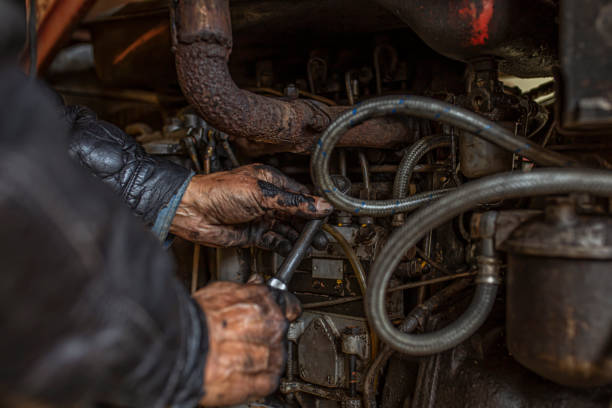 An older American truck driver repairing a machine American driver repairing and old truck repairman photos stock pictures, royalty-free photos & images