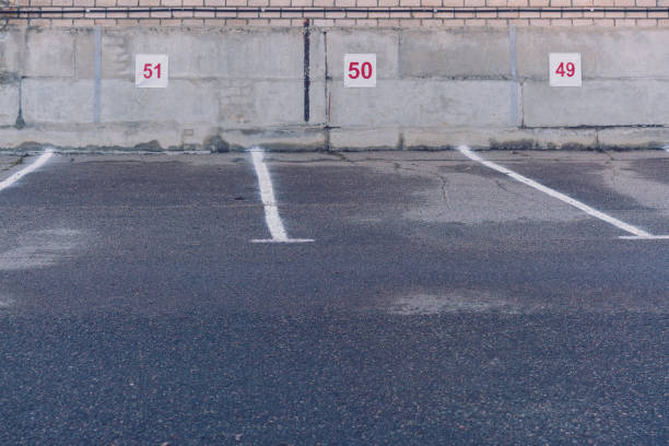istock empty spacious parking area with place numbers on grey wall in spring morning 1227431040