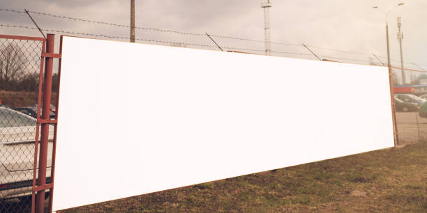 istock large white advertising panel on chain-link fence near open parking lot 1227431047