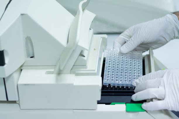 Researcher or scientific introducing a plate in quantitative PCR machine in a biotechnology laboratory Researcher or scientific introducing a 96 wells plate in quantitative PCR machine/ Thermocycler for DNA or RNA quantification in a biotechnology laboratory quantitative research stock pictures, royalty-free photos & images