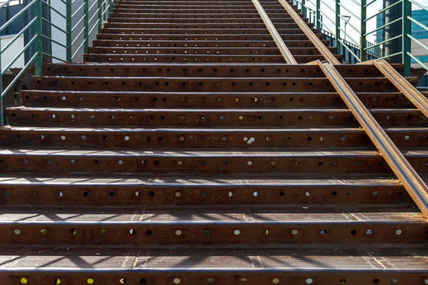 Iron stairs with guides for wheelchairs and prams. Stairs are made of construction iron channels and beams. Background with space for your creativity - lettering, signature, or logo