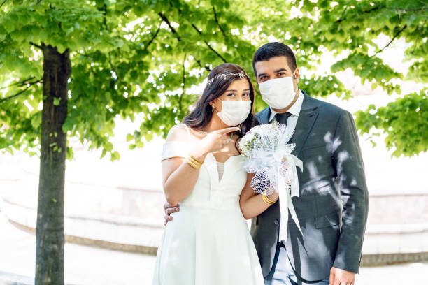 istock bride and groom in a face protection mask 1227435117