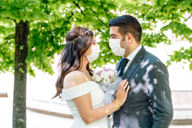 bride and groom in a face protection mask - wedding behavior horizontal men imagens e fotografias de stock