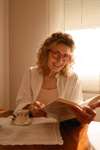 istock Woman reading and drinking tea 1227436011