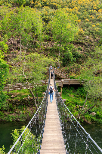 Arouca, Portugal - April 28, 2019: Suspended pedestrian bridge over the Paiva river, giving access to the Paiva walkways with people to cross.