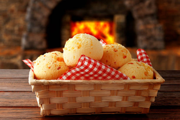 домашний сырный хлеб, традиционная бразильская закуска, в корзине после выхода из духовки на деревенском кухонном столе. - cooked bread food cup стоковые фото и изображения