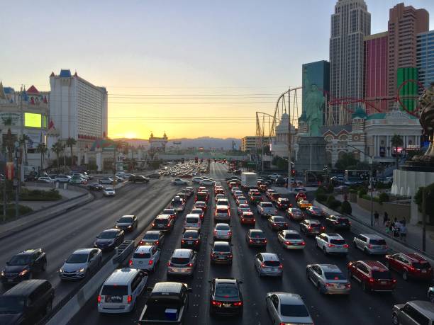 Las Vegas the city that never sleeps Las Vegas Blvd traffic in Nevada The sun sets in the city that never sleeps on Oct 18th 2019 Photograph taken from the pedestrian bridge that connects neighboring casinos. Tourists and casino works making their way to their next destination. excalibur stock pictures, royalty-free photos & images