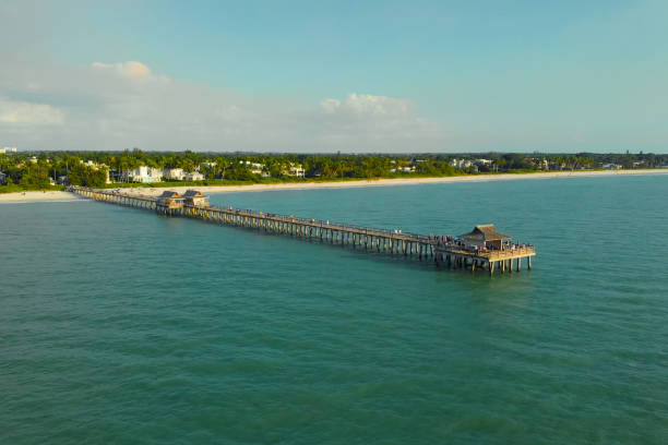 vista desde el océano hasta el muelle con turistas - florida naples florida pier beach fotografías e imágenes de stock