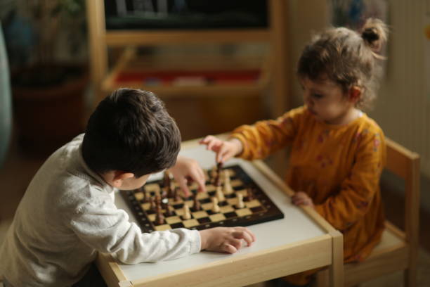 istock Little girl playing chess with her brother 1227445028