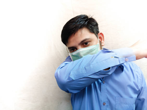 istock Man in face mask Cough on arm 1227445041