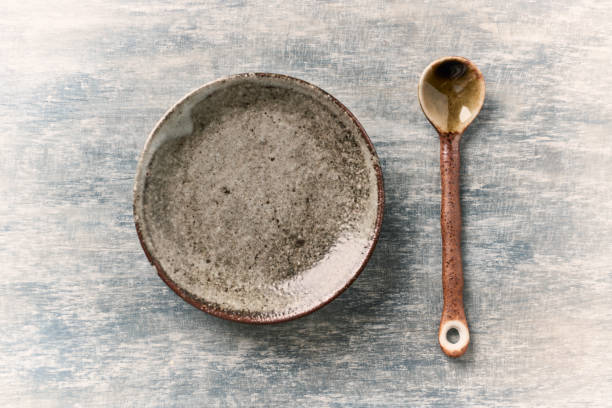 istock Empty ceramics plate and spoon on rustic wooden background. Top view. Copy space. 1227450361