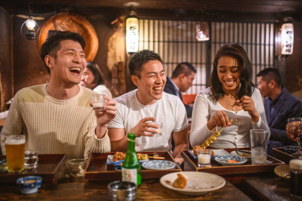 istock Multi-Ethnic Friends Drinking Sake and Laughing at Izakaya 1227451753