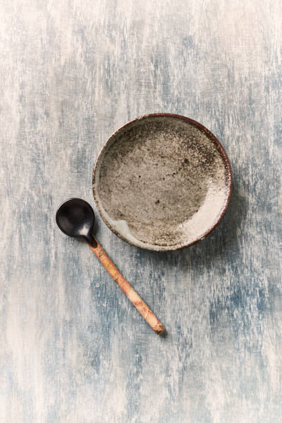istock Empty ceramics plate and spoon on rustic wooden background. Top view. Copy space. 1227451784