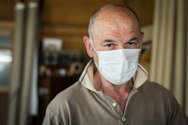 hombres artesanos 60-65 años, con máscara protectora trabajando en aislamiento en su taller, tiro en la cabeza - foto de stock - senior adult 60 65 years people occupation fotografías e imágenes de stock