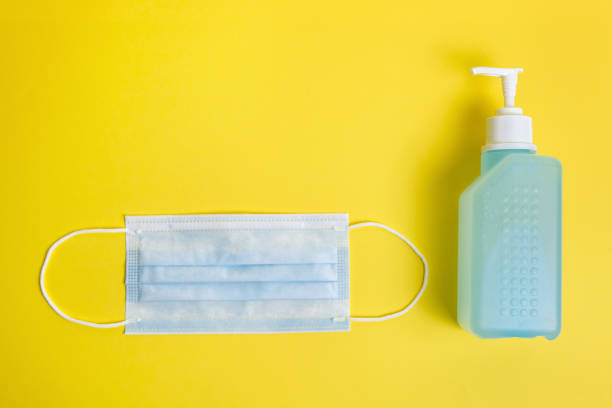 istock mask and disinfectant gel on a yellow background 1227452400