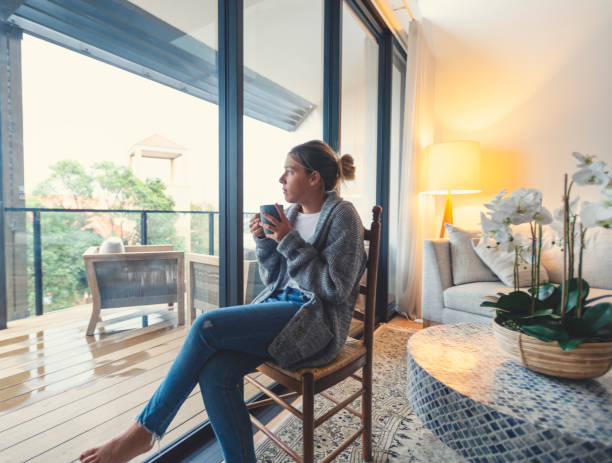 istock Woman looking through the window drinking tea or coffee. 1227453286