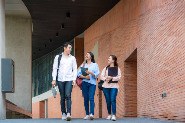 istock Asian three students are walking and talking together in university hall during break in University. Education, Learning, Student, Campus, University, Lifestyle concept. 1227453503