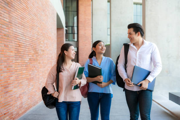 istock Asian three students are walking and talking together in university hall during break in University. Education, Learning, Student, Campus, University, Lifestyle concept. 1227453506