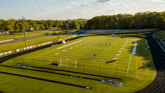 Pasadena, Maryland, USA - May 7, 2020: Just a very few people do workouts at the Chesapeake High School stadium, practicing social distancing, because of the COVID-19 pandemic and the stay at home order in effect.