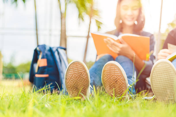 University students sit and read on the grass.