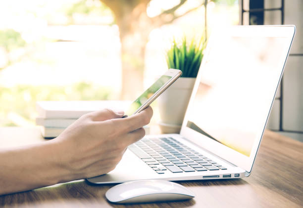 istock Hand of business man working from home using laptop computer to internet online on desk, lifestyle of new normal, social distancing, freelance work in stay home and look phone, communication concept. 1227469236