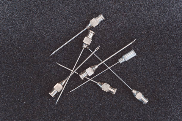 metal needles for old syringes on a dark table stock photo