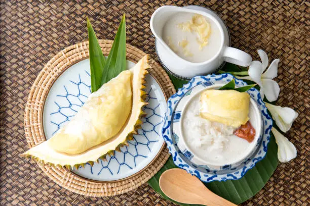 Photo of Sweet Sticky Rice With Durian And Coconut Milk Sauce,Thai sweet sticky rice with durian, Thai style tropical dessert,  isolated on white background, selective focus