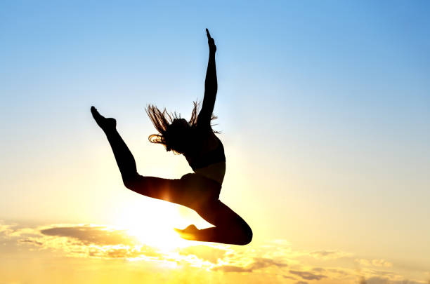 istock Graceful gymnast dancer jumping leaps against sunset 1227474451