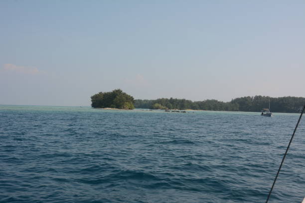istock A row of islands and a small boat passing by 1227476253