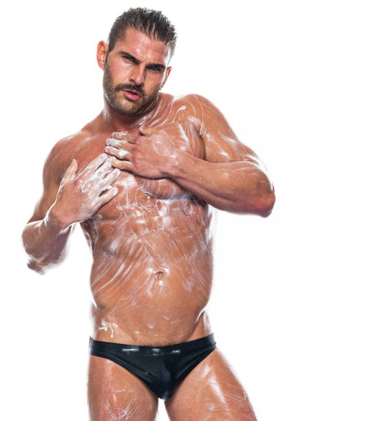Caucasian male standing in front of white background wearing racing briefs Waist up of aged 30-39 years old with short hair caucasian male standing in front of white background wearing racing briefs who is a sex symbol who is cleaning shower men falling water soap sud stock pictures, royalty-free photos & images