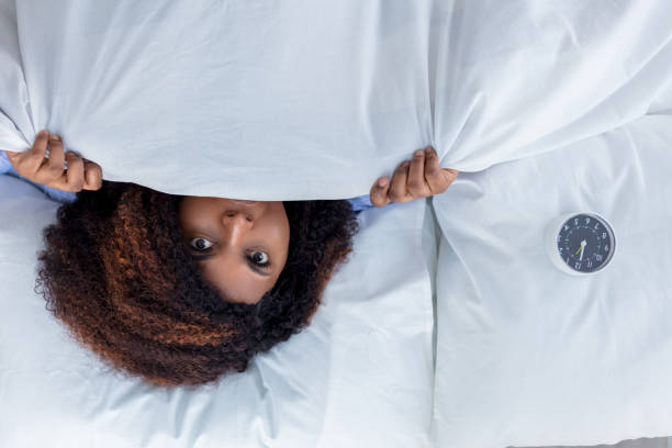 istock emotional woman hiding under the white blanket 1227480950