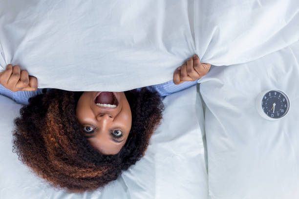 istock african awesome woman screaming while lying in the bed 1227481111