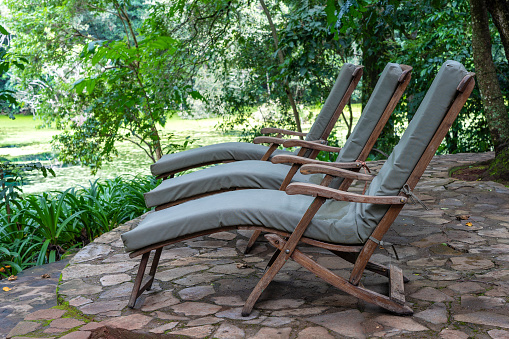 Three cozy sun loungers on the tropical garden terrace near lake. Tanzania, east Africa, close up