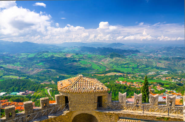 San Marino, September 18, 2018: Aerial top panoramic view landscape with valley, green hills, fields, villages and stone fortress wall and tower with merlons stock photo