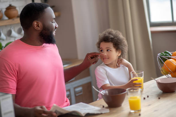 istock Dark-haired african american father touching his daughters cheek and smiling 1227490863