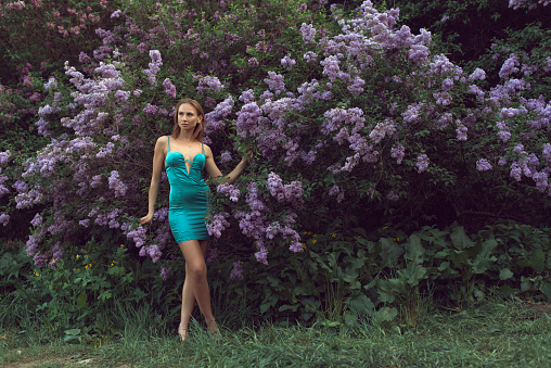 Walk with a young woman in the lilac flowering season