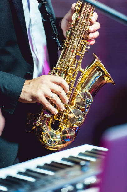 musikinstrument saxophon ausnahaufnahme. hände auf einem musikinstrument. - close up musical instrument saxophone jazz stock-fotos und bilder