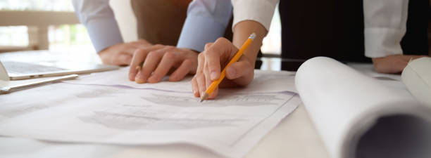 istock Two engineers consulting on their project with blueprint on white desk 1227493577