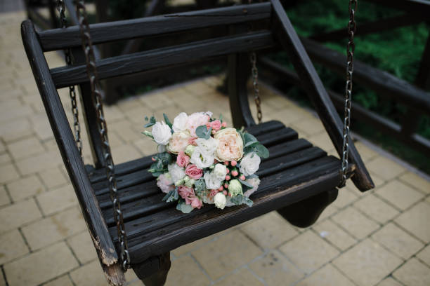 istock Wedding bouquet on a wooden old swing. 1227496106