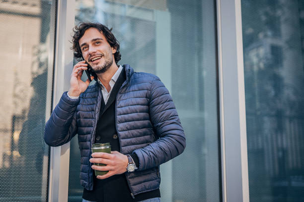 istock Handsome man talking on mobile on the street downtown 1227497569